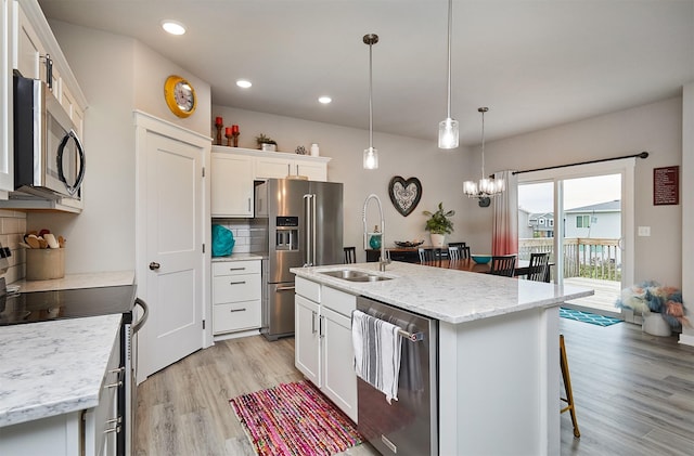 1917 Southbridge Dr, Adel, IA 50003 - kitchen with appliances with stainless steel finishes, backsplash, light wood-style flooring, a kitchen bar, and recessed lighting