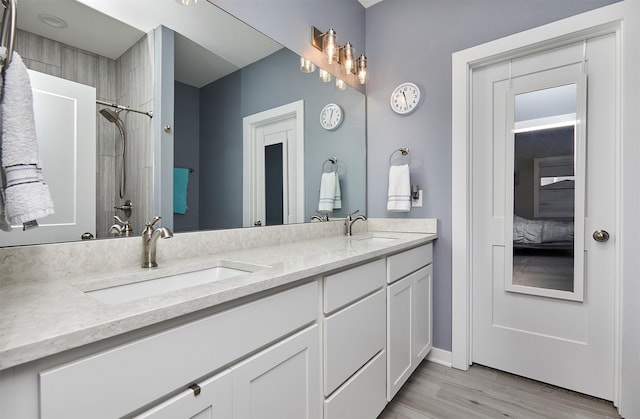 1917 Southbridge Dr, Adel, IA 50003 - bathroom featuring double vanity, wood finished floors, connected bathroom, and a shower