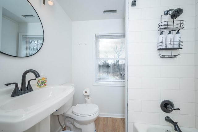 211 Park Ave, Des Moines, IA 50315 - bathroom with a sink, wood finished floors, toilet, baseboards, and shower / washtub combination