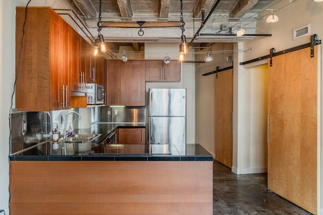 112 11th St Unit 506, Des Moines, IA 50309 - kitchen with appliances with stainless steel finishes, a barn door, a sink, brown cabinetry, and finished concrete flooring