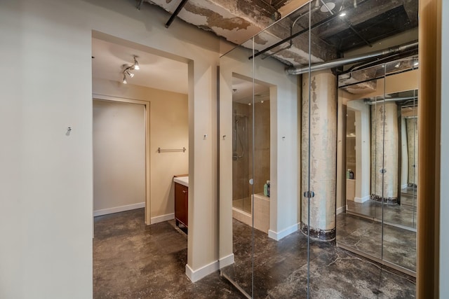 112 11th St Unit 506, Des Moines, IA 50309 - full bathroom with vanity, a stall shower, finished concrete flooring, and baseboards