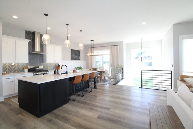 5015 153rd St, Urbandale, IA 50323 - kitchen featuring wall chimney exhaust hood, gas stove, a sink, light countertops, and decorative backsplash