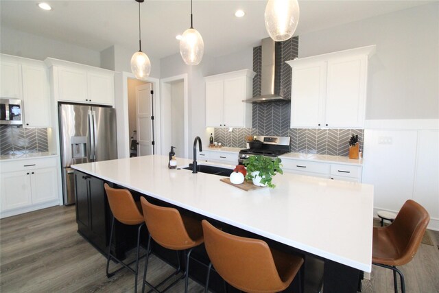 5015 153rd St, Urbandale, IA 50323 - kitchen featuring wall chimney exhaust hood, appliances with stainless steel finishes, a sink, tasteful backsplash, and white cabinets