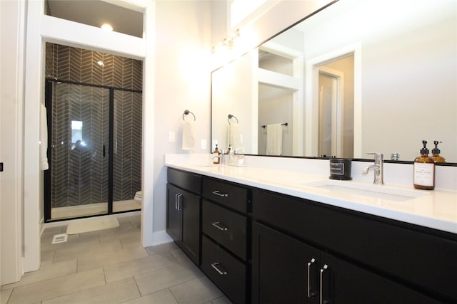 5015 153rd St, Urbandale, IA 50323 - full bathroom with a stall shower, toilet, double vanity, and tile patterned flooring