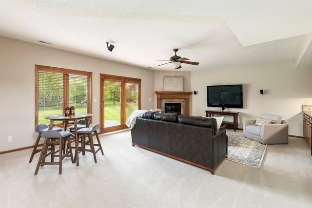 3605 151st St, Urbandale, IA 50323 - living area featuring ceiling fan, light carpet, a glass covered fireplace, and baseboards