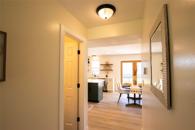 712 63rd St, West Des Moines, IA 50266 - hall featuring a sink and light wood-style flooring