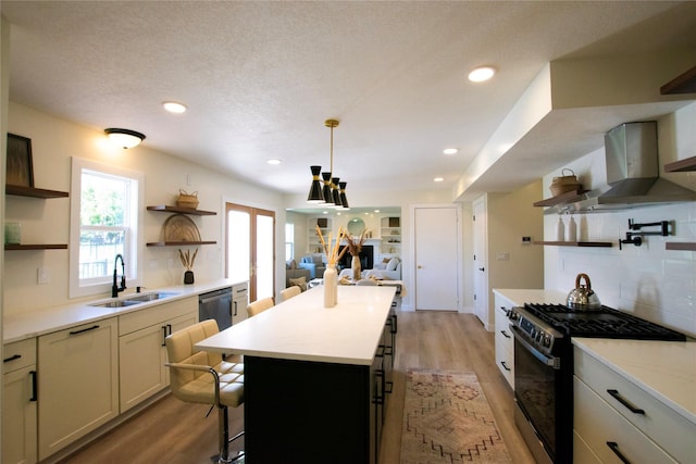 712 63rd St, West Des Moines, IA 50266 - kitchen with open shelves, range with gas cooktop, a sink, wall chimney range hood, and light wood-style floors