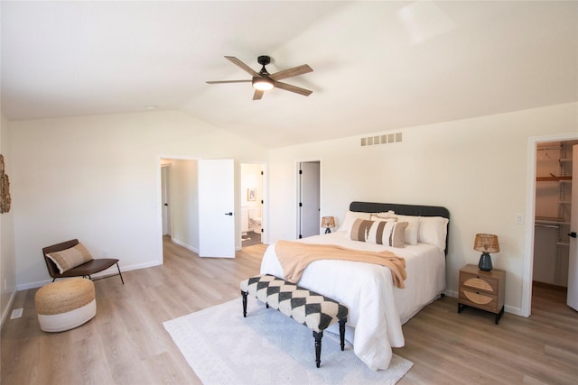 712 63rd St, West Des Moines, IA 50266 - bedroom featuring a walk in closet, light wood-style flooring, lofted ceiling, and baseboards