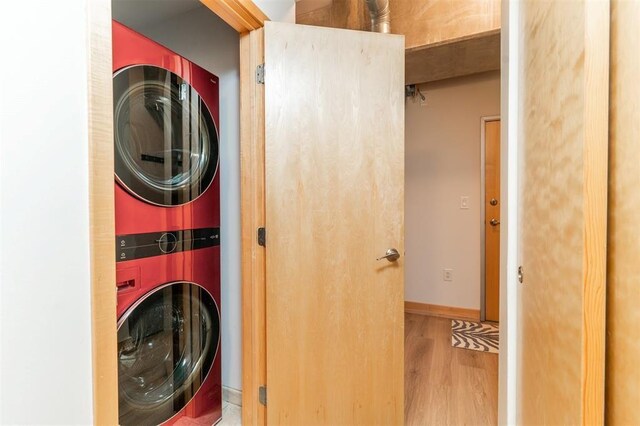 119 4th St Unit 102, Des Moines, IA 50309 - laundry room featuring stacked washer / drying machine, wood finished floors, and baseboards