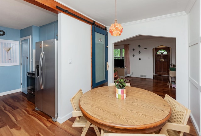 1819 57th St, Des Moines, IA 50310 - dining room featuring a barn door, wood finished floors, baseboards, and ornamental molding