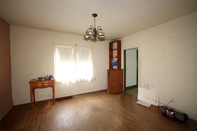 109 Greene St, Boone, IA 50036 - unfurnished dining area with a chandelier, wood-type flooring, and baseboards