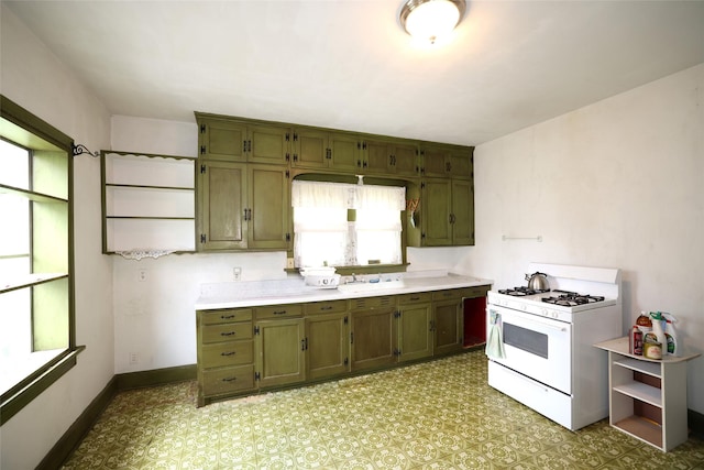 109 Greene St, Boone, IA 50036 - kitchen with gas range gas stove, light countertops, baseboards, and a sink