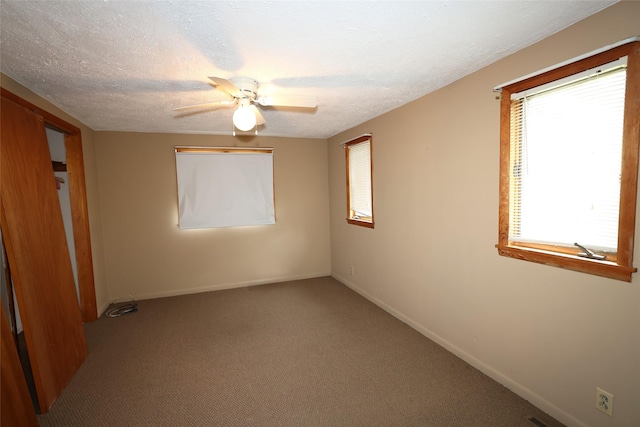 109 Greene St, Boone, IA 50036 - unfurnished bedroom with multiple windows, carpet floors, baseboards, and a textured ceiling