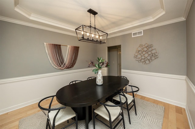 123 62nd St, West Des Moines, IA 50266 - dining room with a tray ceiling, a chandelier, light wood-type flooring, crown molding, and baseboards