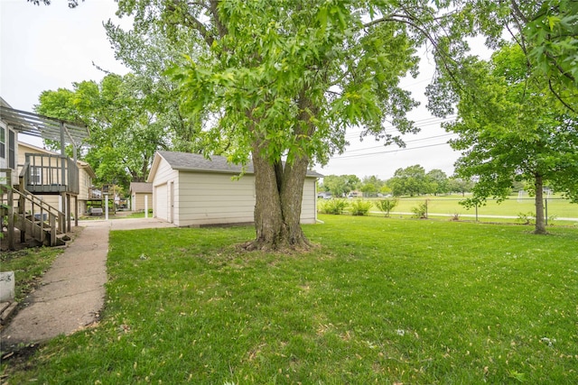 406 SE Trilein Dr, Ankeny, IA 50021 - view of grassy yard featuring an outbuilding, a deck, a garage, and stairs