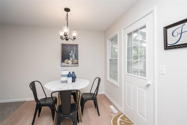 406 SE Trilein Dr, Ankeny, IA 50021 - dining area with light wood-style floors, a chandelier, and baseboards
