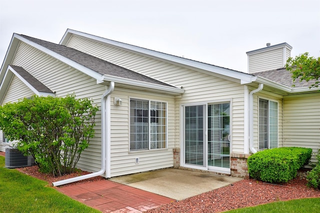 6200 Ep True Pkwy Unit 601, West Des Moines, IA 50266 - property entrance featuring a patio, a shingled roof, cooling unit, and a chimney