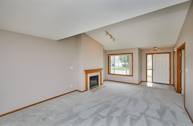 6200 Ep True Pkwy Unit 601, West Des Moines, IA 50266 - unfurnished living room with baseboards, light colored carpet, a tiled fireplace, track lighting, and a textured ceiling