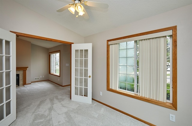 6200 Ep True Pkwy Unit 601, West Des Moines, IA 50266 - carpeted spare room with lofted ceiling, baseboards, a ceiling fan, a premium fireplace, and french doors
