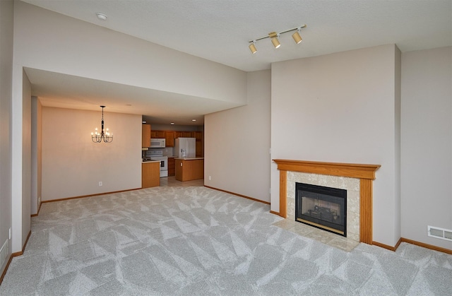 6200 Ep True Pkwy Unit 601, West Des Moines, IA 50266 - unfurnished living room featuring light carpet, baseboards, a chandelier, and rail lighting