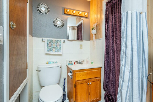 404 E 21st St S, Newton, IA 50208 - bathroom featuring tile walls, toilet, vanity, and wainscoting