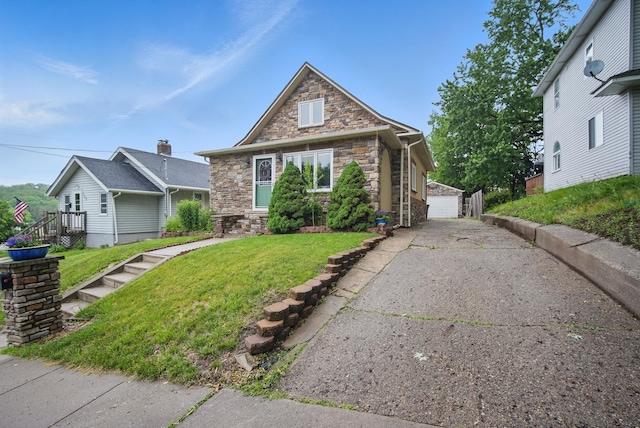 819 Olinda Ave, Des Moines, IA 50315 - view of front of property with stone siding, a front yard, an outdoor structure, and a detached garage