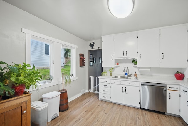 819 Olinda Ave, Des Moines, IA 50315 - kitchen with stainless steel dishwasher, light countertops, a sink, and white cabinetry