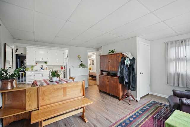 819 Olinda Ave, Des Moines, IA 50315 - dining room featuring a paneled ceiling, light wood-style floors, and baseboards
