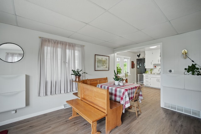 819 Olinda Ave, Des Moines, IA 50315 - dining area with light wood finished floors, a paneled ceiling, and baseboards
