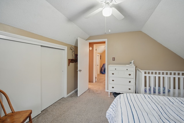 819 Olinda Ave, Des Moines, IA 50315 - carpeted bedroom with vaulted ceiling, a closet, a ceiling fan, and a textured ceiling