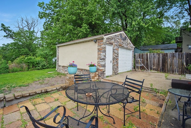 819 Olinda Ave, Des Moines, IA 50315 - view of patio / terrace featuring an outbuilding, outdoor dining space, and a detached garage