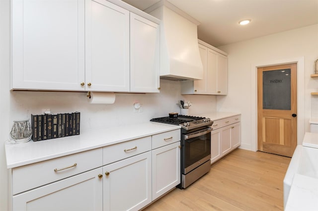 5018 NE Seneca Dr, Ankeny, IA 50021 - kitchen with stainless steel range with gas cooktop, light wood finished floors, light countertops, recessed lighting, and white cabinets