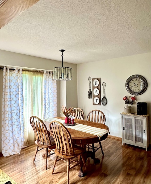 902 W Filmore St, Winterset, IA 50273 - dining room with wood finished floors, a textured ceiling, and baseboards