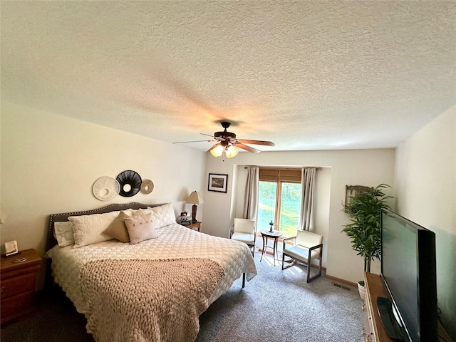 902 W Filmore St, Winterset, IA 50273 - bedroom featuring dark carpet, ceiling fan, and a textured ceiling