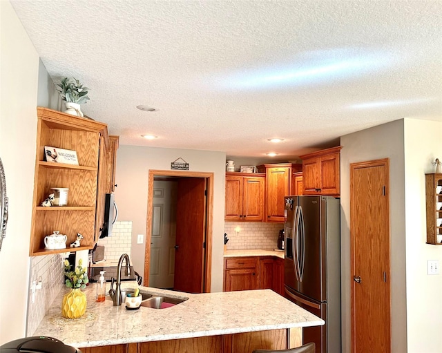 902 W Filmore St, Winterset, IA 50273 - kitchen featuring stainless steel refrigerator with ice dispenser, a sink, a peninsula, open shelves, and tasteful backsplash