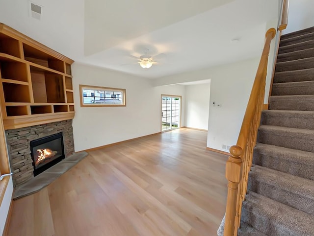 2101 Meadow Ct Unit 1304, Des Moines, IA 50320 - unfurnished living room with a fireplace, wood finished floors, stairway, ceiling fan, and baseboards