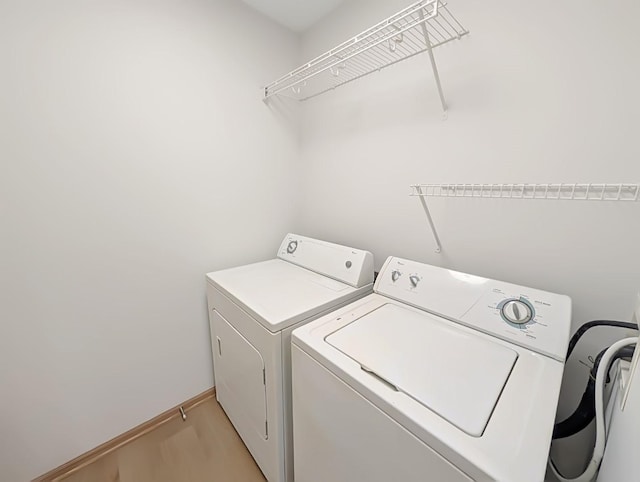2101 Meadow Ct Unit 1304, Des Moines, IA 50320 - washroom with washing machine and clothes dryer, light wood-style floors, and baseboards