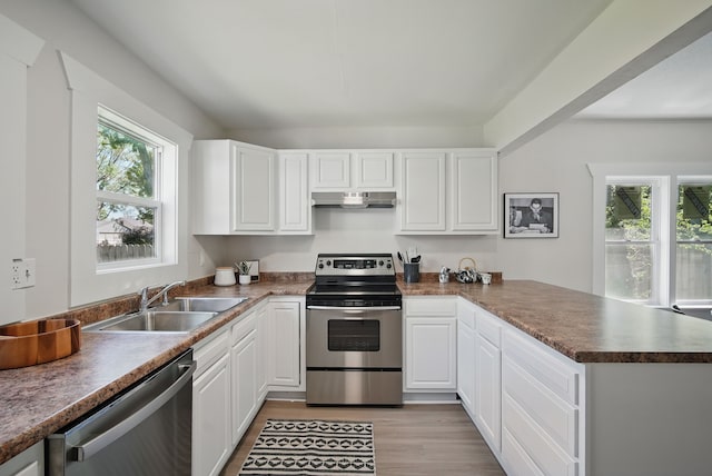 1519 Searle St, Des Moines, IA 50317 - kitchen with appliances with stainless steel finishes, a peninsula, under cabinet range hood, and white cabinets