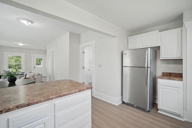 1519 Searle St, Des Moines, IA 50317 - kitchen with freestanding refrigerator, light wood-style flooring, white cabinets, and open floor plan