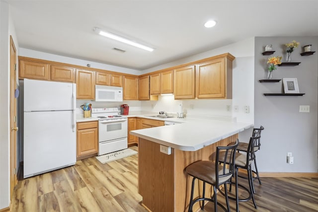 1265 SE 6th St Unit 104, Grimes, IA 50111 - kitchen with white appliances, a peninsula, light wood finished floors, a kitchen bar, and recessed lighting