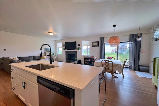 1932 Strauss Ave, Adel, IA 50003 - kitchen featuring dishwasher, open floor plan, a sink, and wood finished floors