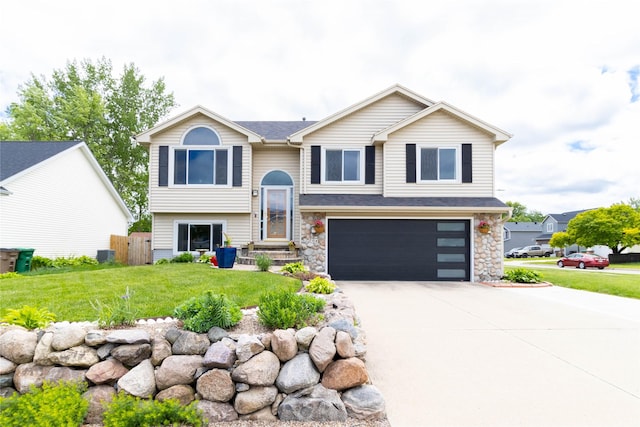704 13th St SE, Altoona, IA 50009 - raised ranch featuring an attached garage, concrete driveway, and stone siding
