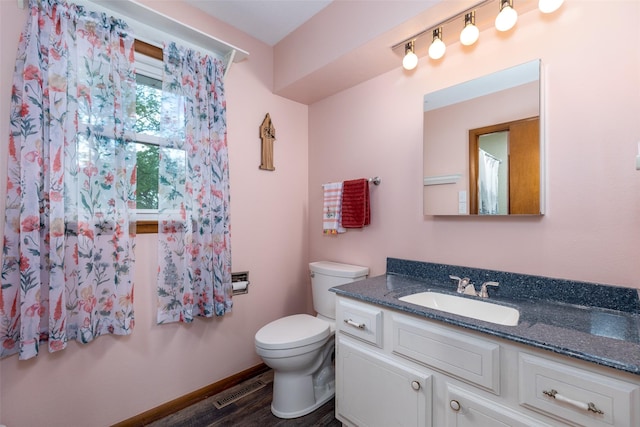500 8th St, Waukee, IA 50263 - bathroom featuring vanity, toilet, wood finished floors, and baseboards
