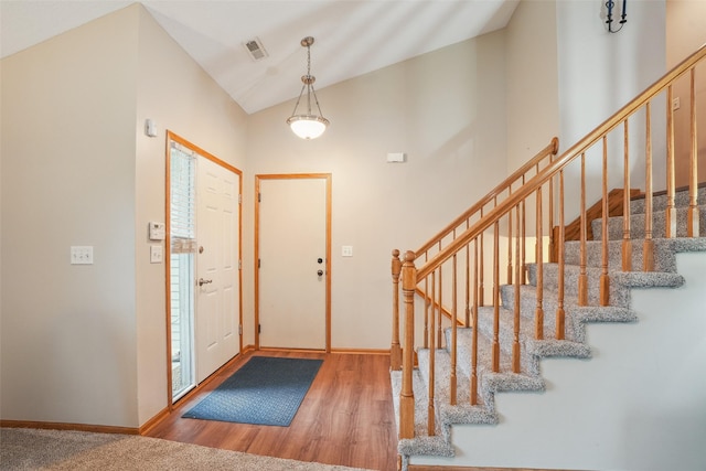 5200 Pine Valley Dr, Pleasant Hill, IA 50327 - entryway with wood finished floors, stairs, baseboards, and high vaulted ceiling