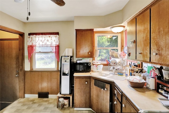 3517 50th St, Des Moines, IA 50310 - kitchen with a sink, light countertops, brown cabinetry, and healthy amount of natural light