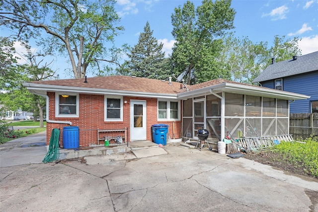 3517 50th St, Des Moines, IA 50310 - rear view of property featuring a sunroom, a patio area, and brick siding