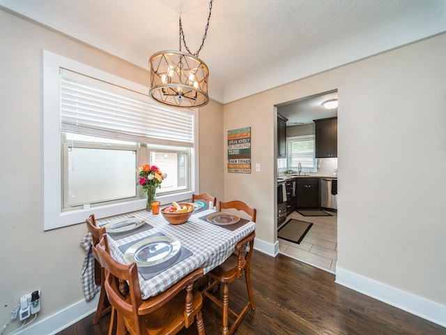 4022 Clinton Ave, Des Moines, IA 50310 - dining room with a chandelier, dark wood-type flooring, and baseboards