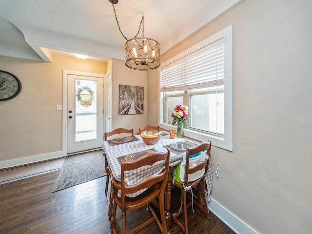 4022 Clinton Ave, Des Moines, IA 50310 - dining space featuring a chandelier, baseboards, and wood finished floors