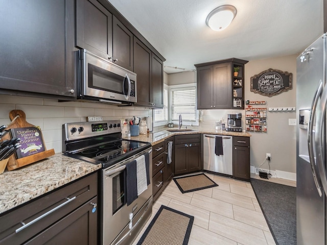 4022 Clinton Ave, Des Moines, IA 50310 - kitchen with stainless steel appliances, a sink, tasteful backsplash, and dark brown cabinets