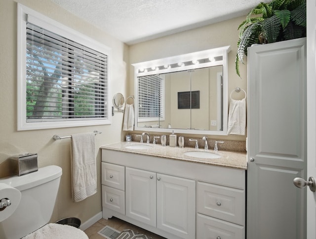 5113 Panorama Dr, Panora, IA 50216 - full bath featuring double vanity, toilet, tile patterned flooring, and a textured ceiling